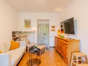 a living room with a white couch and a tv at Holiday Home Castello by Interhome in Dervio
