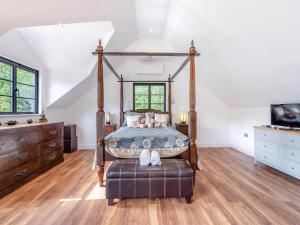 1 dormitorio con cama con dosel y TV en Foxton Barn, en Harrietsham 10 fotos más