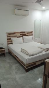 a bedroom with a large bed with white sheets at Hotel Sunshine Palace in Indore