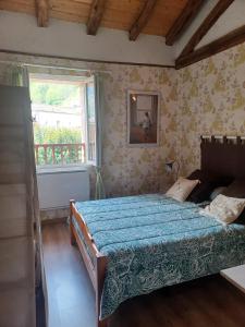 a bedroom with a bed and a window at La Bergerie in Sost