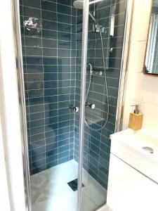una doccia con una porta in vetro in un bagno di Bienvenue à bord a Trouville-sur-Mer