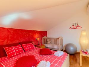 - une chambre avec un lit rouge et un lit bébé dans l'établissement Holiday Home Aurora by Interhome, à Colico