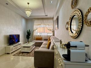 a living room with a couch and a tv at Charming Bright Flat in Historic La Ville Haut in Kenitra