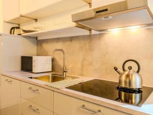 a kitchen with a sink and a tea kettle at Apartment Camping Turisport-2 by Interhome in Dervio