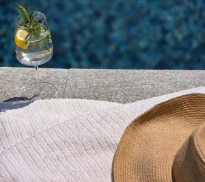 a glass of water and a hat on a table at Casa Reis in San Damiano dʼAsti