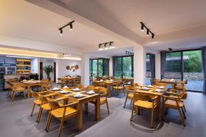 a restaurant with wooden tables and chairs and windows at Hilltop House Resort in Zhangjiajie