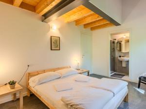 a bedroom with a large bed with white sheets at Apartment Camping Turisport-4 by Interhome in Dervio