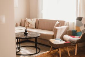 a living room with a couch and a table and chairs at Euphoria Apartment in Alexandroupoli