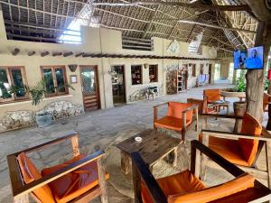 a room with chairs and tables and a room with a table at Lapili Residence in Kiwengwa