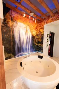 a bath tub in a bathroom with a waterfall mural at Luxury Home Askos in Askós