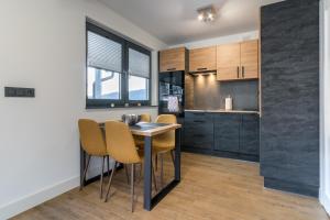 a kitchen and dining room with a table and chairs at DOMINO-domek 1 in Krościenko
