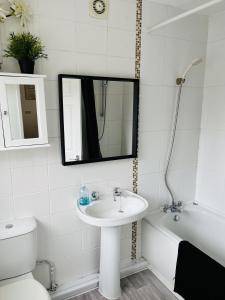 łazienka z umywalką, toaletą i lustrem w obiekcie Ideal 2 bed pay-as-you-stay home in Widnes sleep 5 w mieście Halton