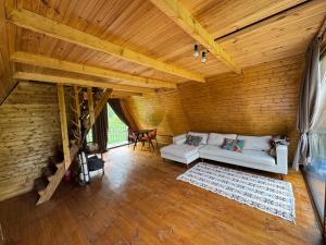 a living room with a white couch and a wooden ceiling at Cottages in Chirdili in Chirdili
