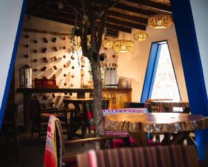 a dining room with tables and chairs and a tree at Ckoi Atacama Lodge in San Pedro de Atacama