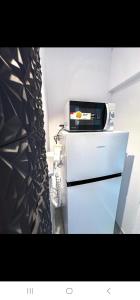 a microwave sitting on top of a refrigerator at AZZURE Apartaments Constanța in Constanţa