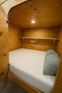 a small bed in a small room with wooden walls at Cubik Rooms in Madrid +14 photos