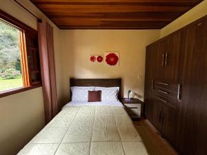 un dormitorio con una cama y una ventana en Chale Sitio Esperança, en Sapucaí-Mirim