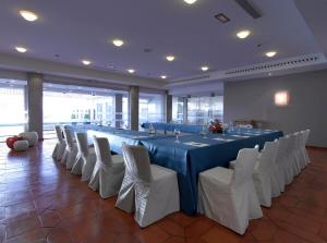 a large room with a long table and white chairs at Parador de Málaga Golf in Málaga +37 photos