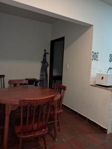 a dining room with a table and chairs and a microwave at Comodidade ao lado da ESALQ USP in Piracicaba +2 photos