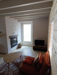 a living room with a couch and a fireplace at La Maisonnette in Lugagnan