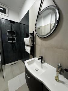 a bathroom with a sink and a mirror and a shower at Sion Residence in Debrecen