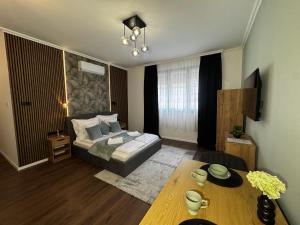 a living room with a bed and a table at Sion Residence in Debrecen