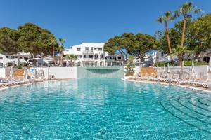 basen z krzesłami, drzewami i budynkami w obiekcie Hotel Palia Dolce Farniente 3 Sup w mieście Cala d´Or