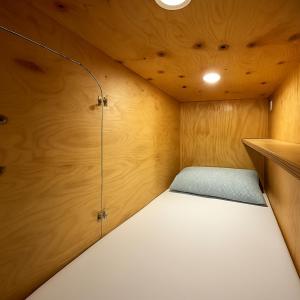 Una cama pequeña en una habitación con paredes de madera. en Cubik Rooms, en Madrid