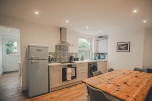 a kitchen with a table and a refrigerator and a stove at Charming 3 Bedroom Home with Garden in Banbury in Banbury
