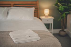 a pile of towels sitting on the end of a bed at Charming 3 Bedroom Home with Garden in Banbury in Banbury