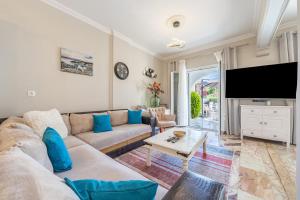 a living room with a couch and a flat screen tv at Donna's luxury home in Kassiopi 300m from the sea in Kassiopi