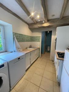 a kitchen with a sink and a white refrigerator at Gîte de la Rochejaquelein in Saint-Fulgent +5 photos
