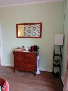 a room with a dresser and a mirror on the wall at Trecastle Chambre d'Hôtes in Châlus