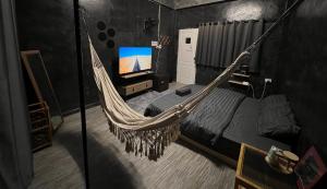 a hammock in a room with a bed and a tv at Stay Strays Hostel in Bangkok