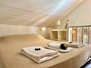 Un dormitorio con dos toallas en una cama. en Duplex confortable avec climatisation et cour - ménage et linge inclus, en La Rochelle