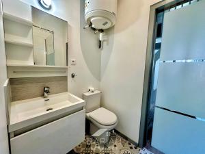 Un baño con inodoro, lavabo y ducha. en Duplex confortable avec climatisation et cour - ménage et linge inclus, en La Rochelle 10 fotos más