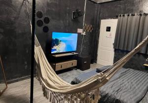 a hammock in a room with a tv and a bed at Stay Strays Hostel in Bangkok +82 photos