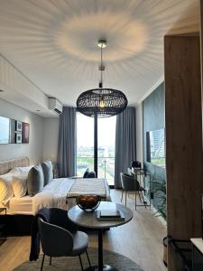 a bedroom with a bed and a table and a chandelier at Explore Ellipse - Peacock Room in Midrand +32 photos