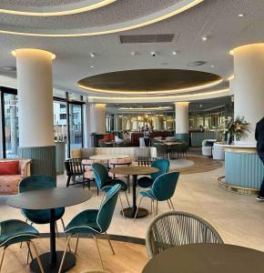 a restaurant with tables and chairs in a lobby at Explore Ellipse - Peacock Room in Midrand