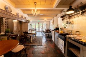 a large kitchen with tables and chairs in a restaurant at Herberg de Lingehoeve in Oosterwijk +35 photos