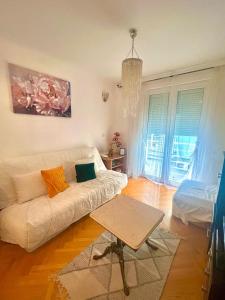 a living room with a white couch and a table at Asami in Vrnjačka Banja