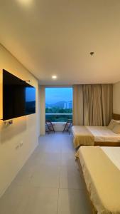 a hotel room with two beds and a flat screen tv at Apartamento inteligente para vacacionar y vivir in Santa Marta