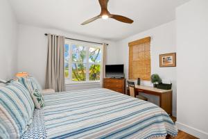 a bedroom with a bed with a ceiling fan at Tropical Princeville Condo with Private Lanai in Princeville +29 photos