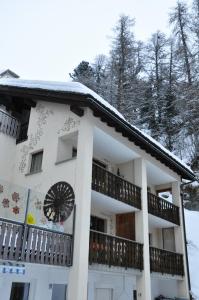 un edificio blanco con techo cubierto de nieve en Ferienwohnungen Seraina, en Sils-Maria