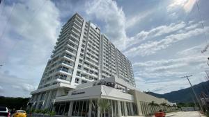 a large white building with a palm tree in front of it at Apartamento inteligente para vacacionar y vivir in Santa Marta