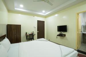 a bedroom with a bed and a tv on the wall at Hotel Marigold Kokapet- A Business Hotel in Hyderabad
