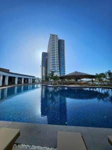 a large swimming pool in a city with tall buildings at Luxurious Apartments at Grand Sapphire Resort & Casino in Bahçeler
