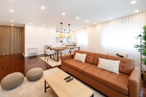 a living room with a couch and a table at Costa Nova Premium Apartment & Pool in Costa Nova