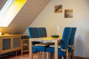 Un comedor con una mesa y sillas azules. en Seestr 37, en Dahme