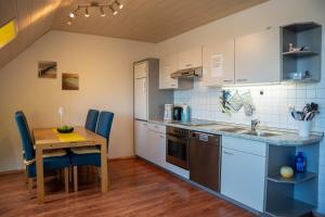 Una cocina con una mesa de madera y una mesa y sillas. en Seestr 37, en Dahme